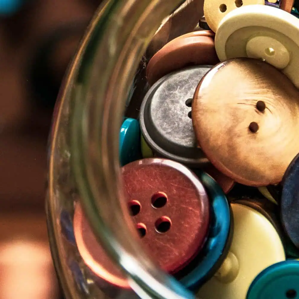 Button collection, colourful wooden and plastic buttons for sewing and crafting projects, close-up shot of diverse buttons in a jar, suitable for fabric and fashion decoration, quality sewing supplies from Fabric & Finery UK.