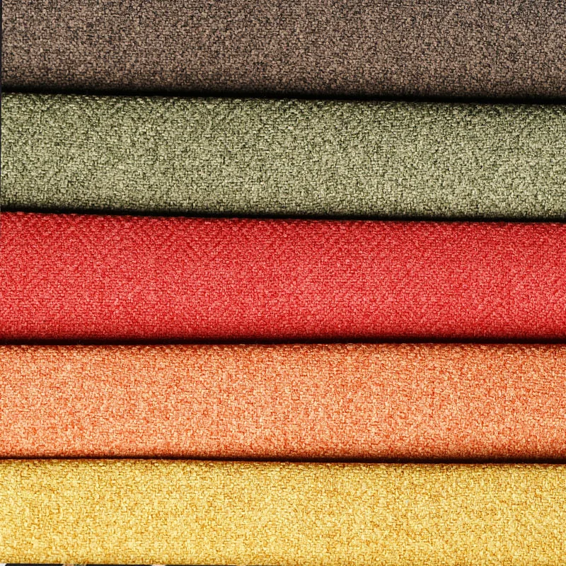 Vibrant stacked fabric upholstery in various colours for dressmaking, home decor, and tailoring, showcasing high-quality textiles from Fabric & Finery.