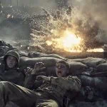 "Two soldiers in combat uniforms take cover behind sandbags as an explosion erupts nearby on a smoky, chaotic battlefield, with flames and debris filling the air."
