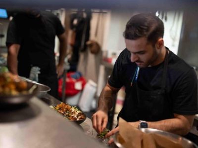 Chef preparing a gourmet dish at Frederic's Restaurant & Bar in New Zealand.