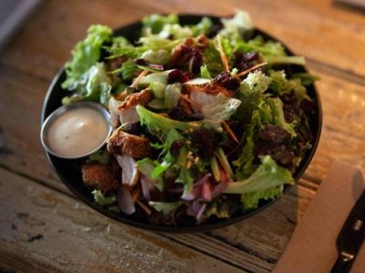 Fresh mixed salad with greens, nuts, and dressing at Frederic's Restaurant & Bar.