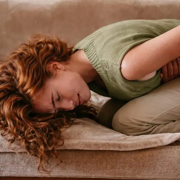 Woman experiencing urinary discomfort, seeking natural relief with fulvic acid.