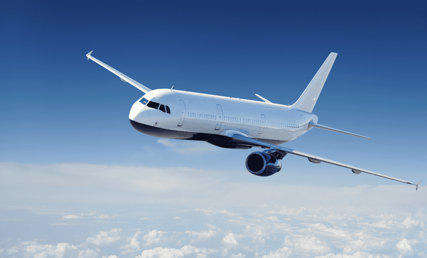 A private jet soaring through a clear blue sky above the clouds, showcasing luxury and modern aviation technology.
