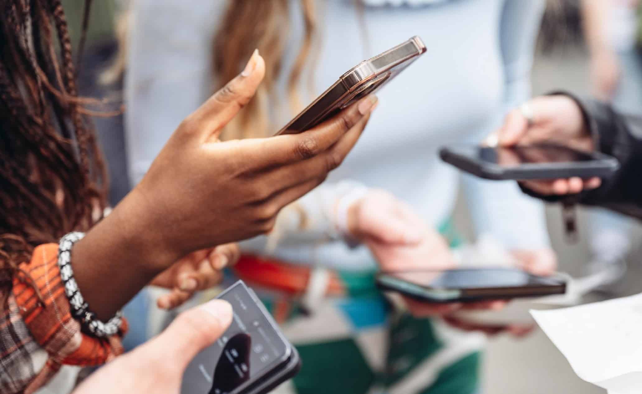 Smartphones being used for mobile payments and social media interaction at a busy outdoor event.