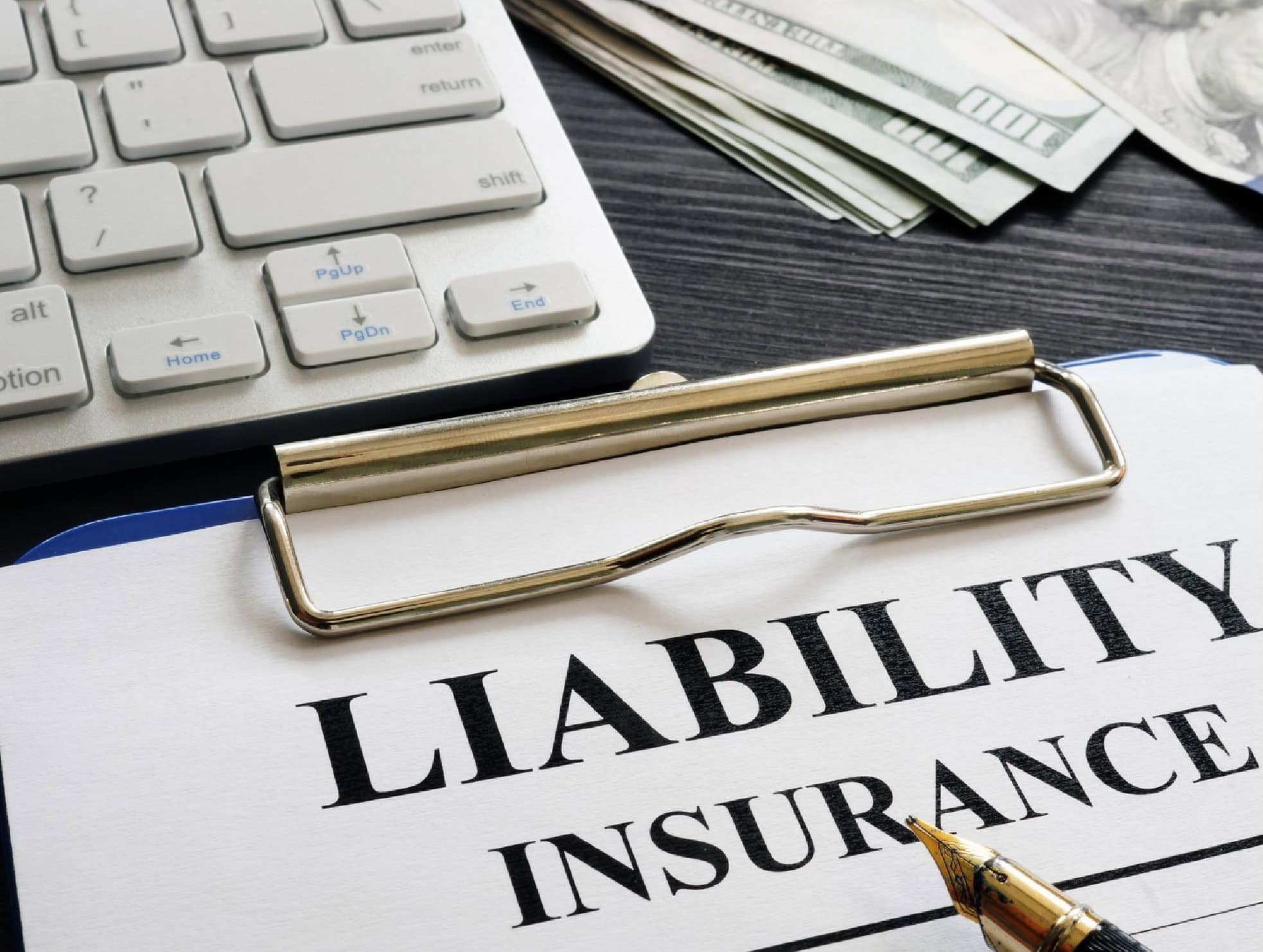 Compliance insurance policy document with a gold pen, calculator, and US dollar bills on a dark wooden desk, symbolising financial and legal protection for businesses.