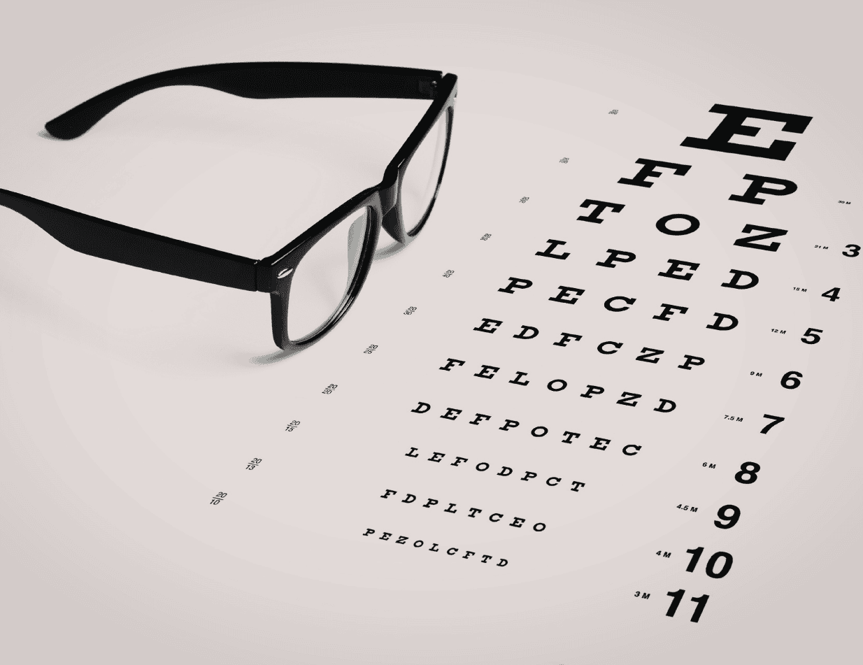 Stylish black glasses lying beside a classic eye chart with optometry measurements, symbolising eye care and vision testing. Perfect for opticians or eye health services.