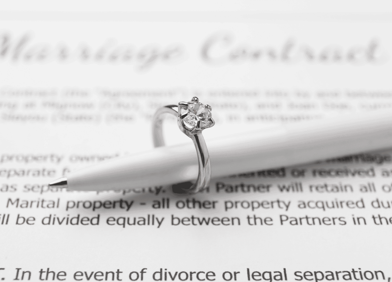 Close-up of a sparkling diamond ring on a legal document, highlighting fine craftsmanship and luxury.