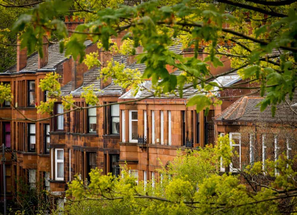 Bright, contemporary townhouses with large windows and brick facades in a city neighbourhood.