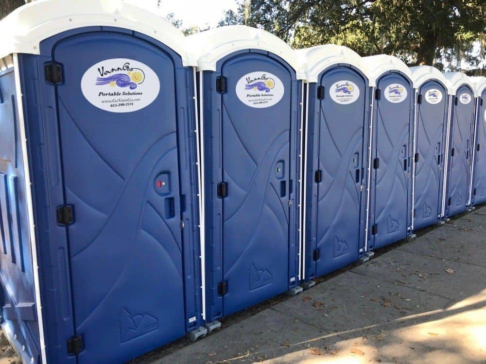 Row of blue portable toilets with VannGo logo for site services.
