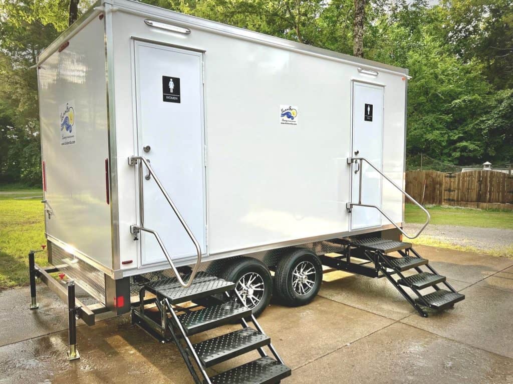 Luxury restroom trailer with two doors and stairs, outdoor setting in Nashville.