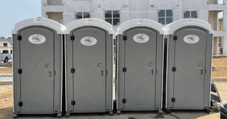 Row of portable restrooms at a construction site for workers' convenience.
