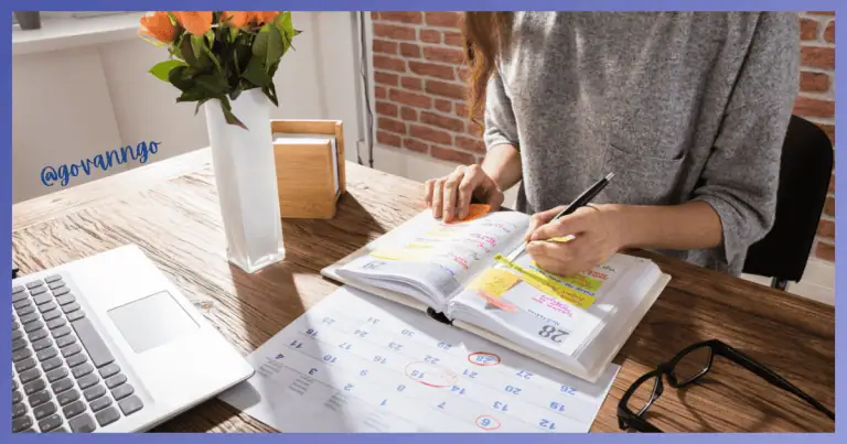 Person planning with calendar and notes for restroom rental scheduling.