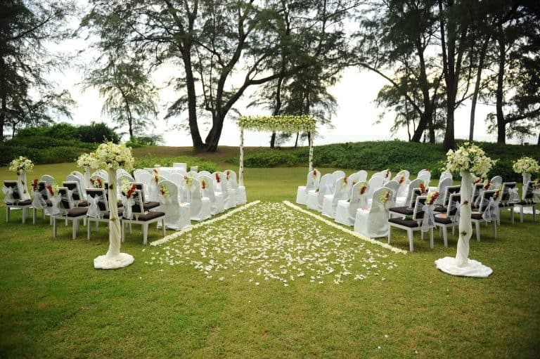Elegant outdoor wedding setup with floral decorations and seating arrangement.