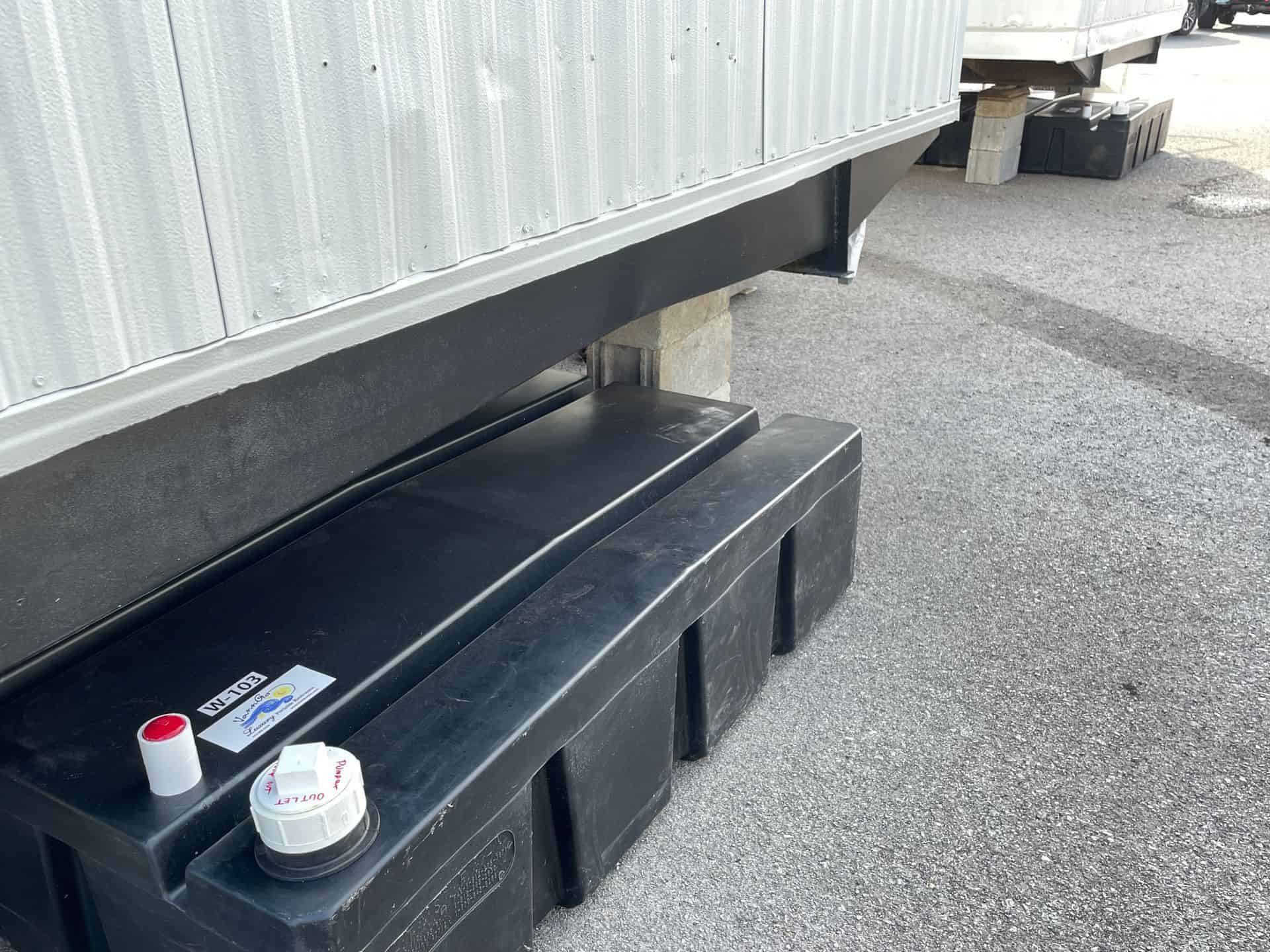 Underground water tank with access steps and valves for site services.