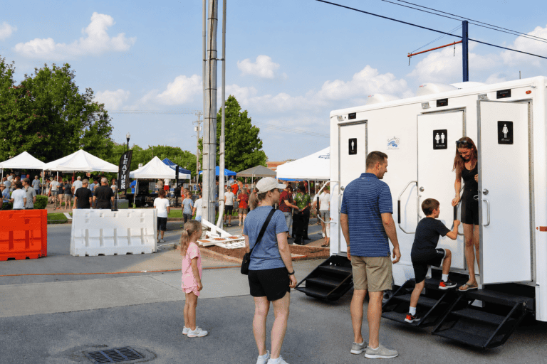 People using portable restrooms at an outdoor event in Nashville.