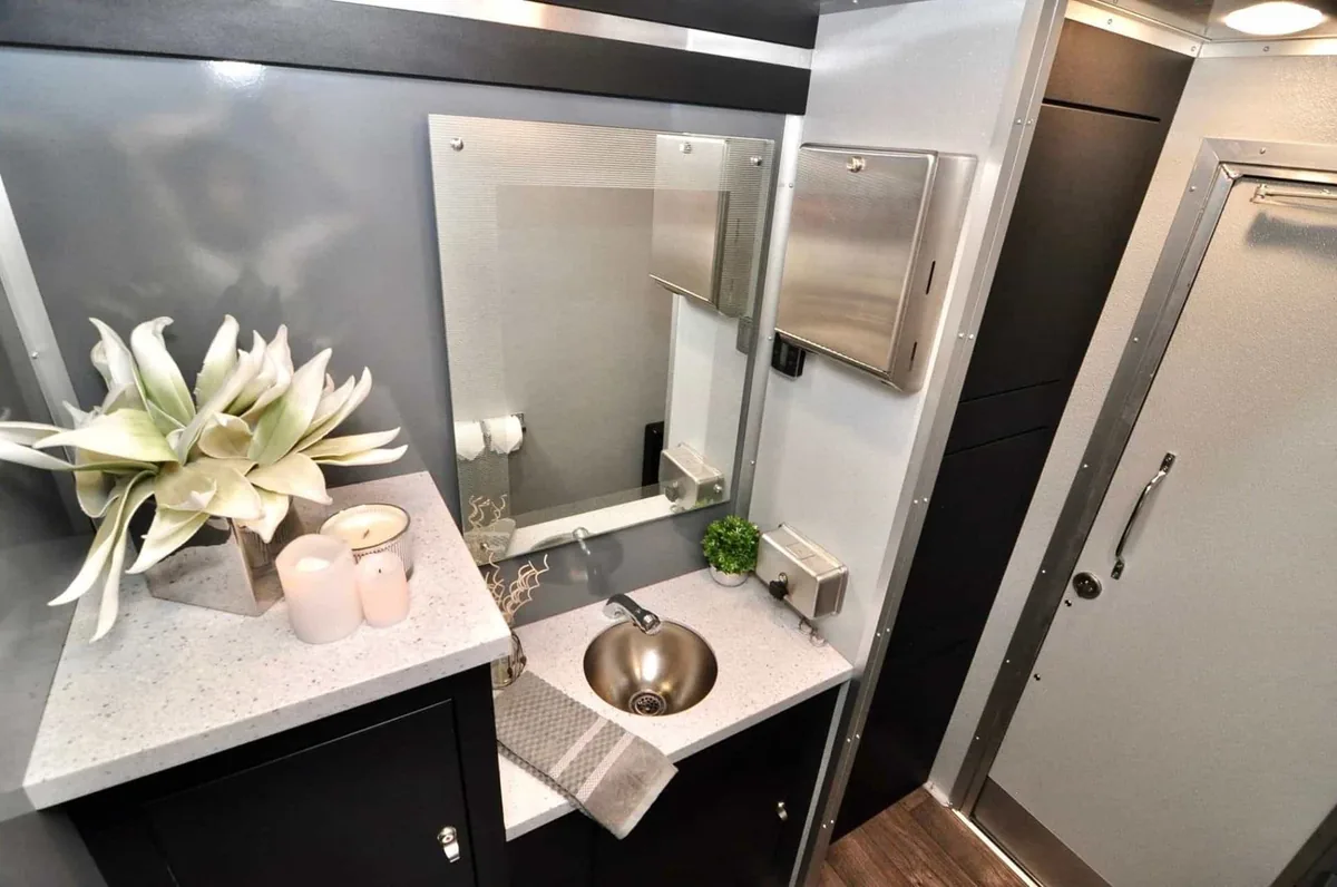 Clean VannGo luxury restroom interior with marble counter and flowers