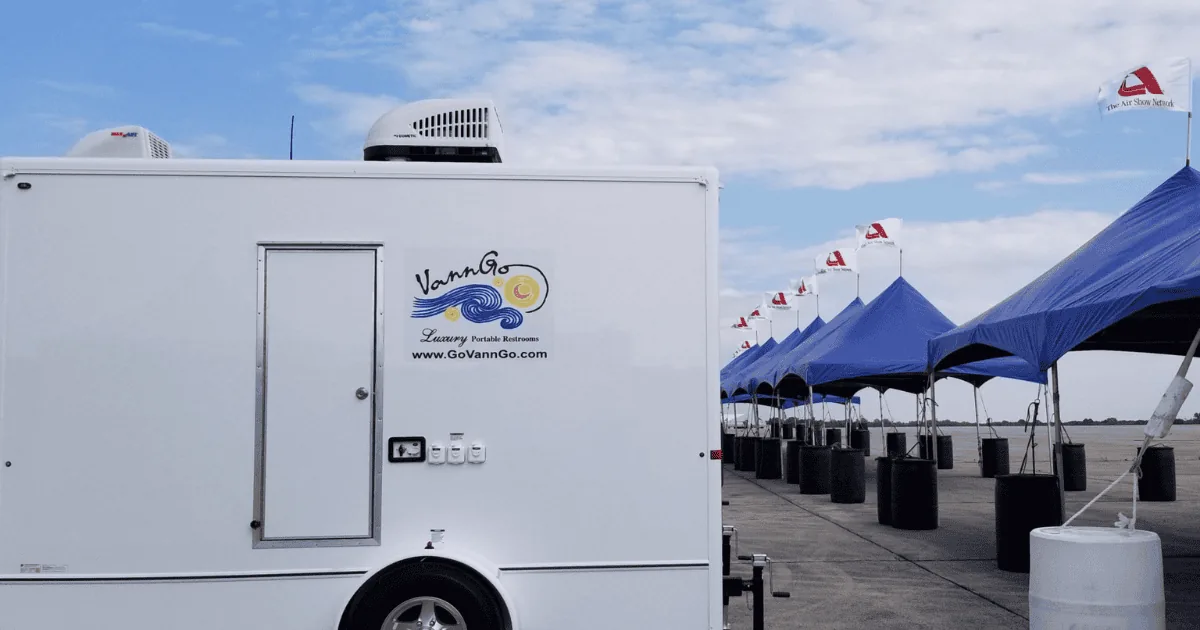 VannGo restroom trailer parked beside event tents at an outdoor gathering in Middle Tennessee