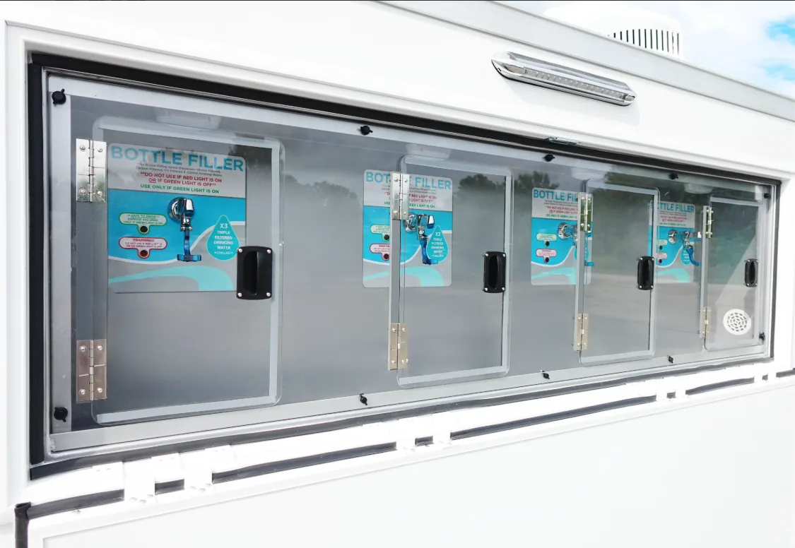 Four water bottle filling stations along the side of a mobile hydration station trailer