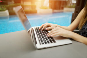 &nbsp;>thisisjustarandomplaceholder<close up woman hands pressing keyboard on laptop sunny day swimming pool | Iberian Press®&nbsp;