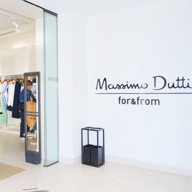 Massimo Dutti storefront interior with a glass door, white walls, and clothes on racks; logo visible on the wall: 'Massimo Dutti for&from'.