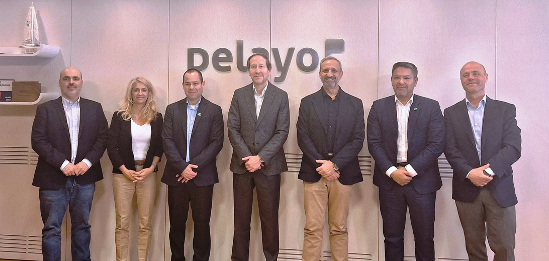 Group of seven professionals in business attire posing in front of a Delayo logo.