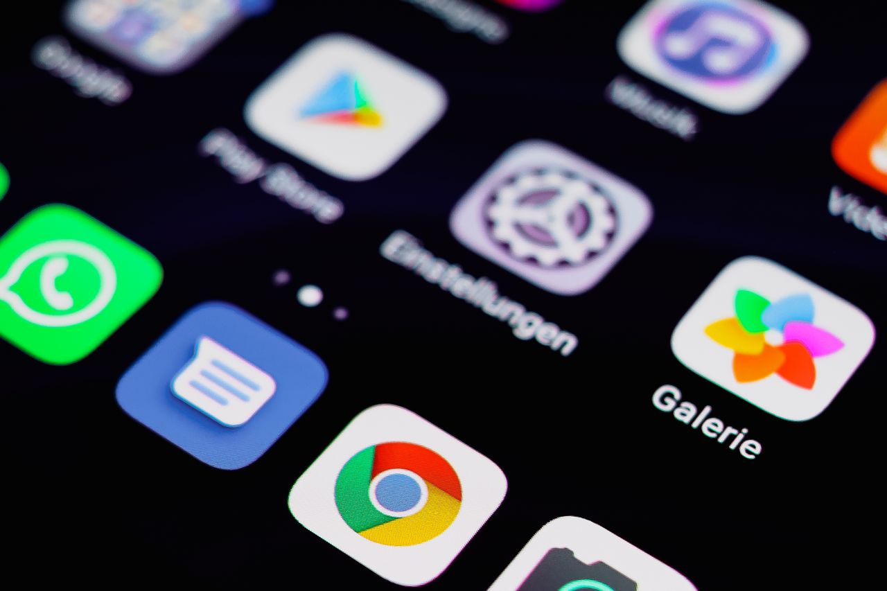 Close-up of a smartphone home screen with colorful app icons, including Chrome and Galerie, on a dark background.