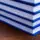 Stack of blue-bound hardcover books stacked on a wooden table surface.