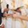 Bride and groom exchange rings during a wedding ceremony, with a clergy member holding a book in the background