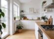 Bright, sunlit kitchen with white cabinets, wooden countertops, and several potted plants along the windowsill and shelves.