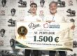 Two men pose with a giant cheque for 1,500 €, winning a ham-cutting contest, in front of sponsor banners with pig illustrations.