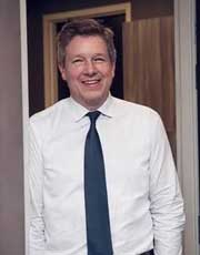 Dr. Brown - Smiling man in white shirt and tie indoors