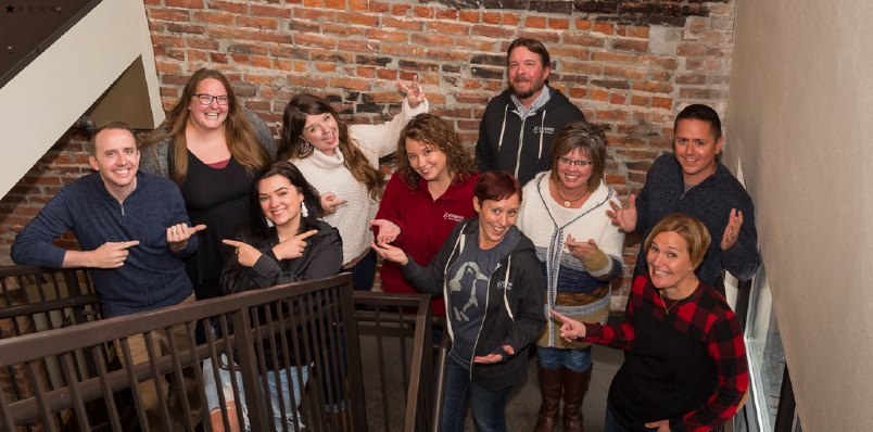 Iceberg 2021 Team Photo. Everyone making silly faces and standing on stairwell with brick background.