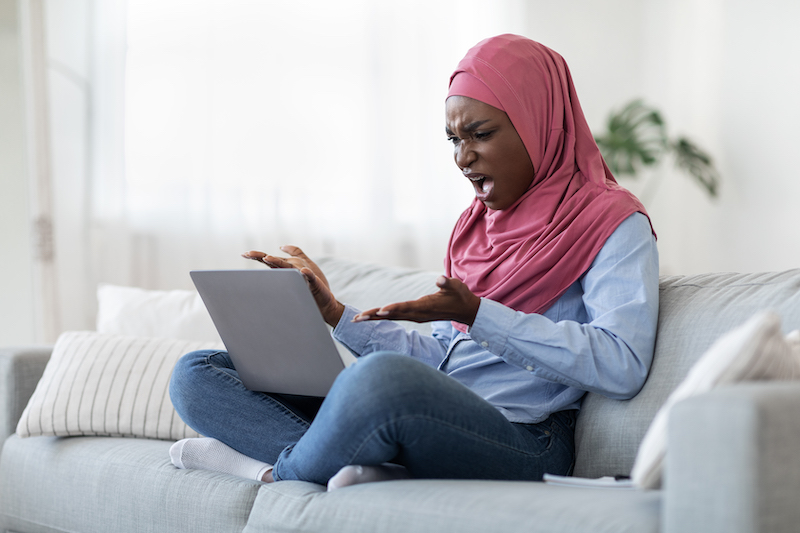 Computer Problems. Angry Black Muslim Lady Having Troubles With Laptop At Home