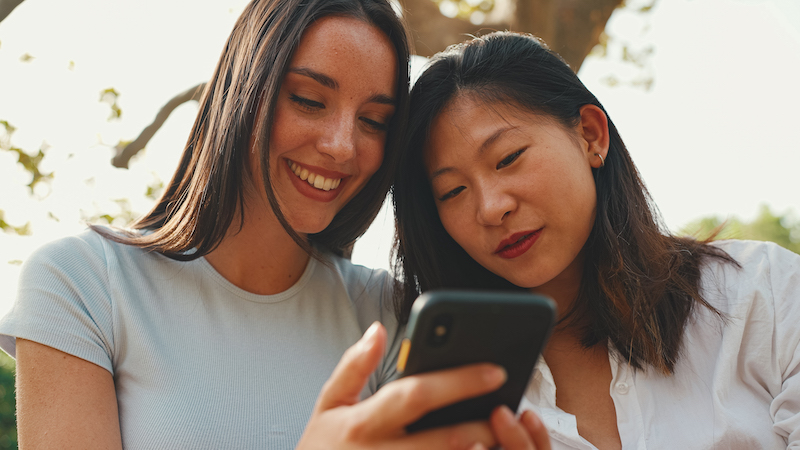 Young Multi Ethnic Smiling Women Are Watching Content On Their Phone.