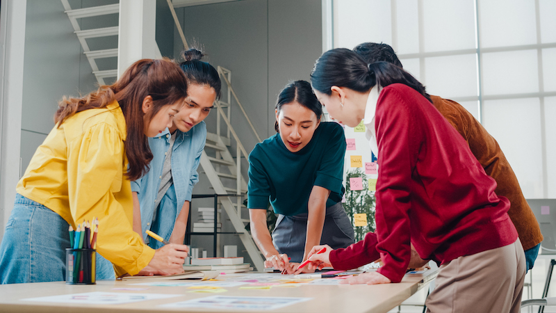 Asian Businessmen And Businesswomen Meeting Brainstorming Ideas About Creative Web Design Planning Application And Developing Template Layout For Mobile Phone Project Working Together In Small Office.