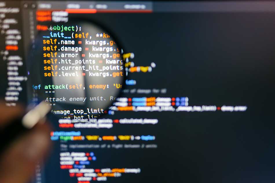 Code On Computer Screen With Magnifying Glass