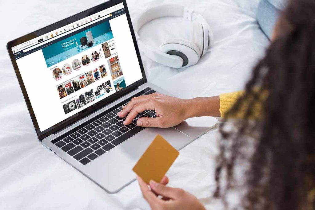 Woman Holding Credit Card And Using Computer