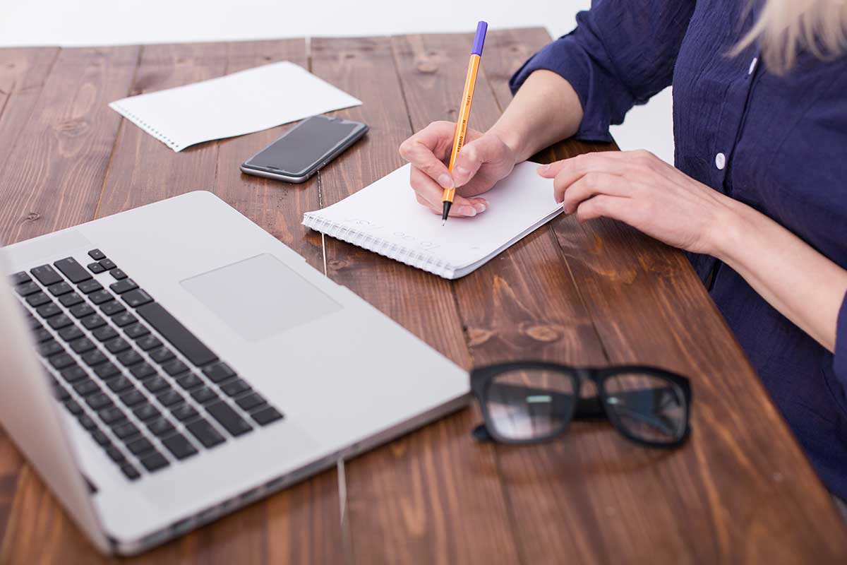 Woman Taking Notes By Laptop