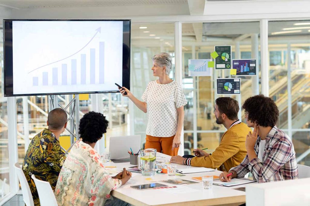 Woman Showing Chart To Colleagues