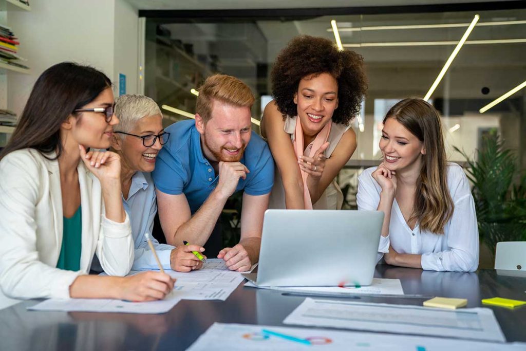 Marketing Professionals Gathered Around A Laptop