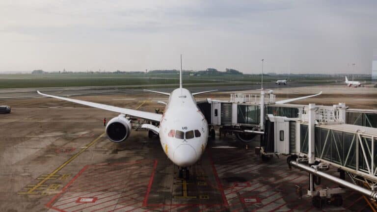 Commercial airplane parked at an airport gate connected to a jet bridge