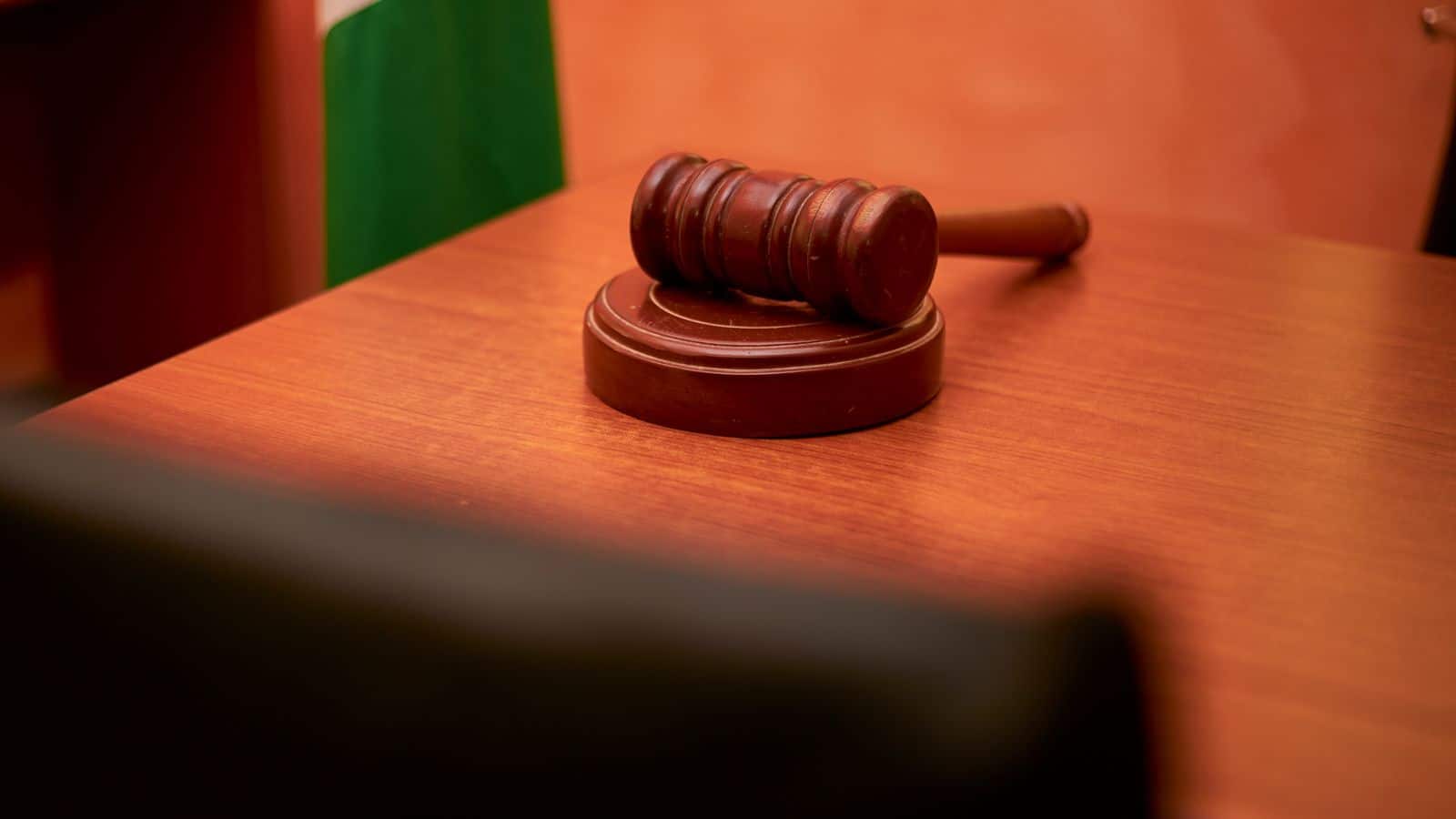 Wooden judicial gavel resting on a courtroom desk
