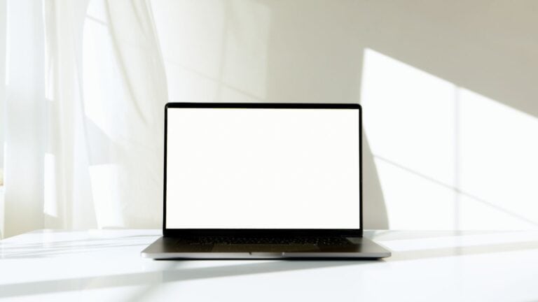 A laptop screen showing a simple leasing funnel chart on a desk beside a set of house keys and a for rent sign leaning n