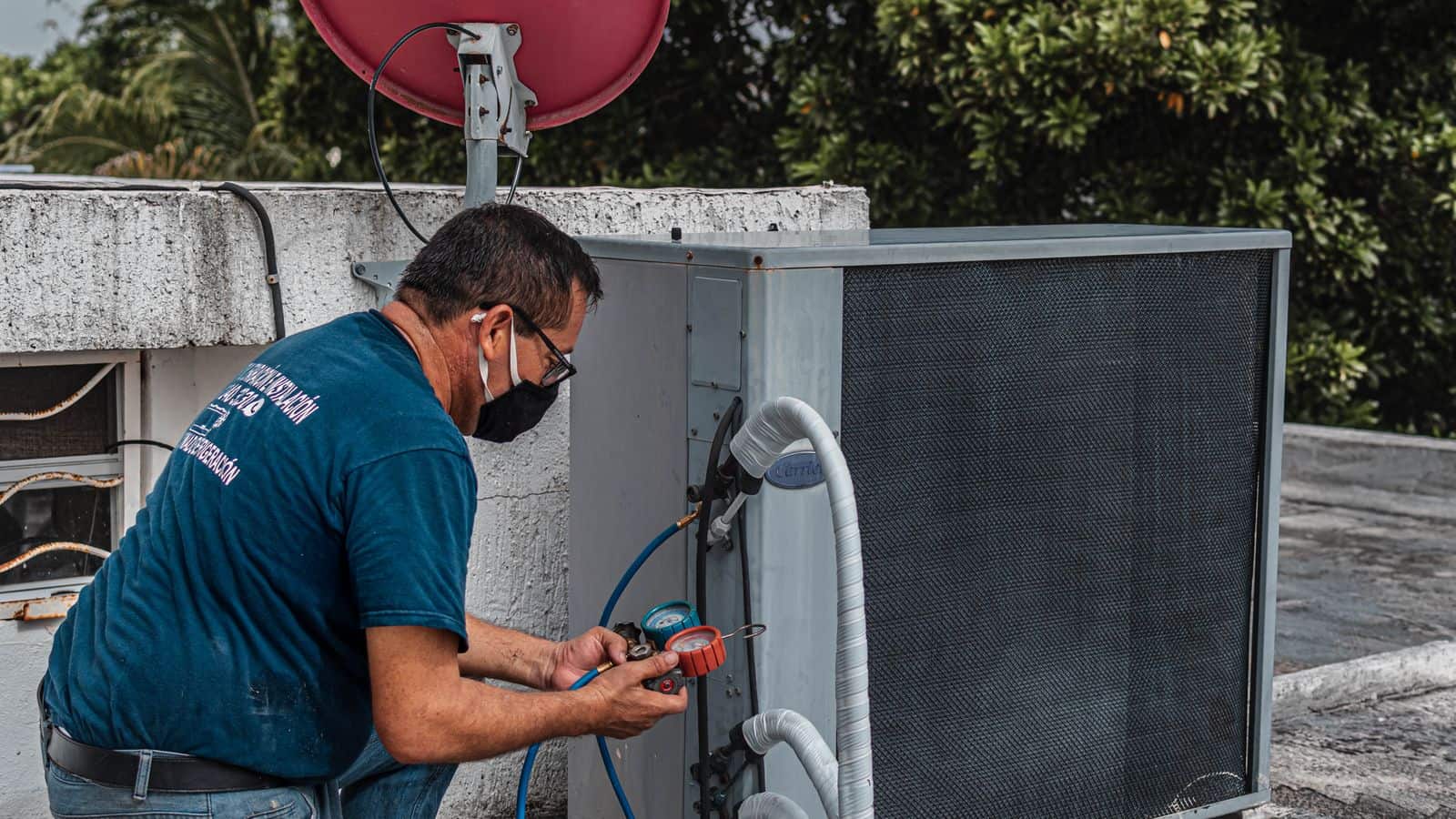 Technician checking an air conditioning unit during a home warranty service call