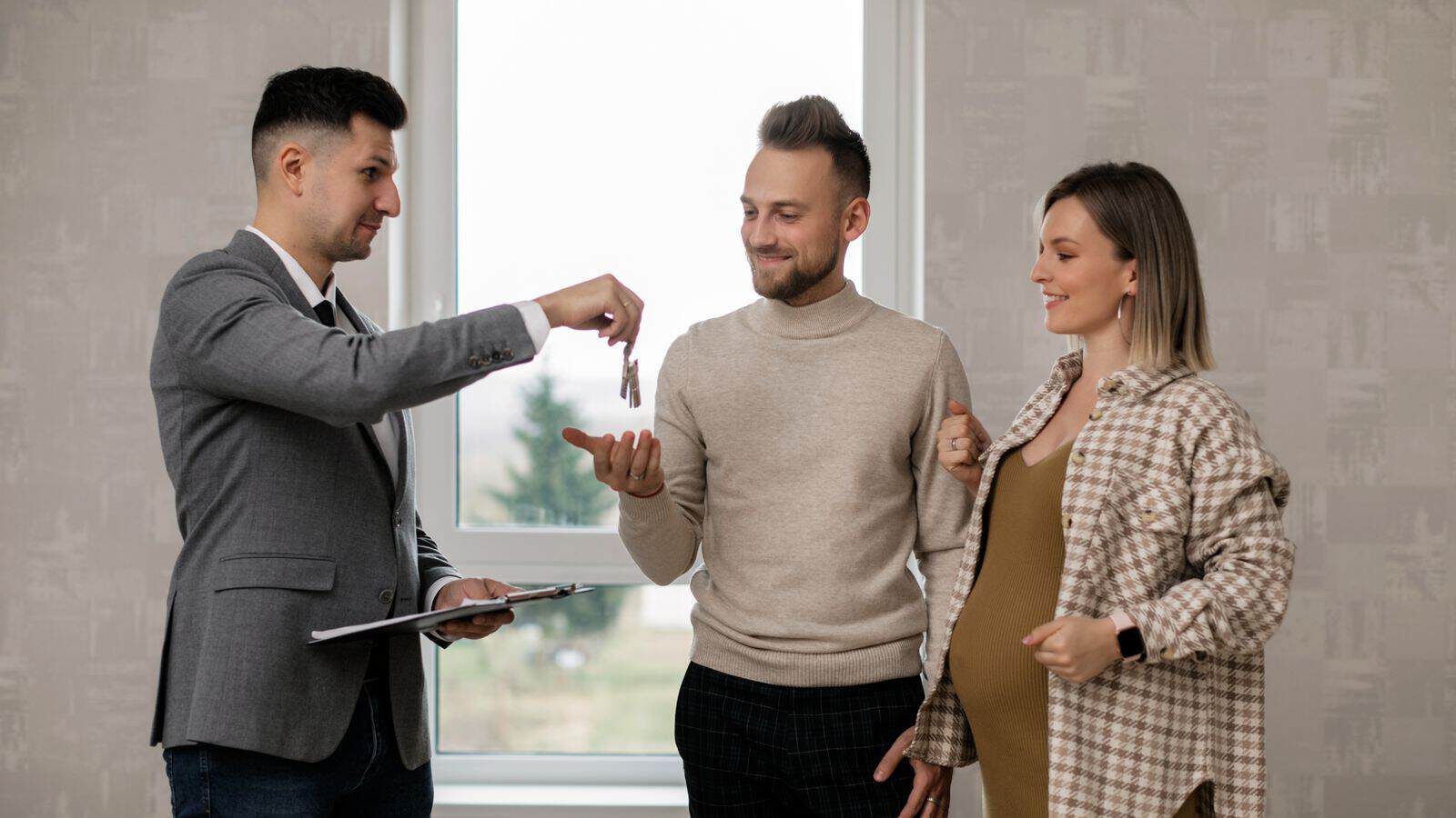 Real estate agent handing over house keys to new owners during a property handoff