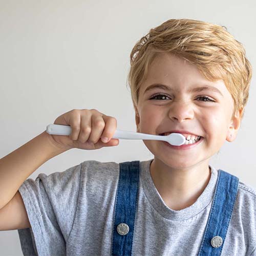 Child brushing their teeth smiling