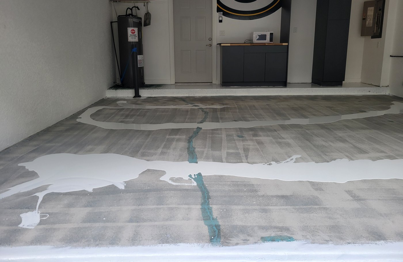 Cracks filled and the base coat going down on a garage floor