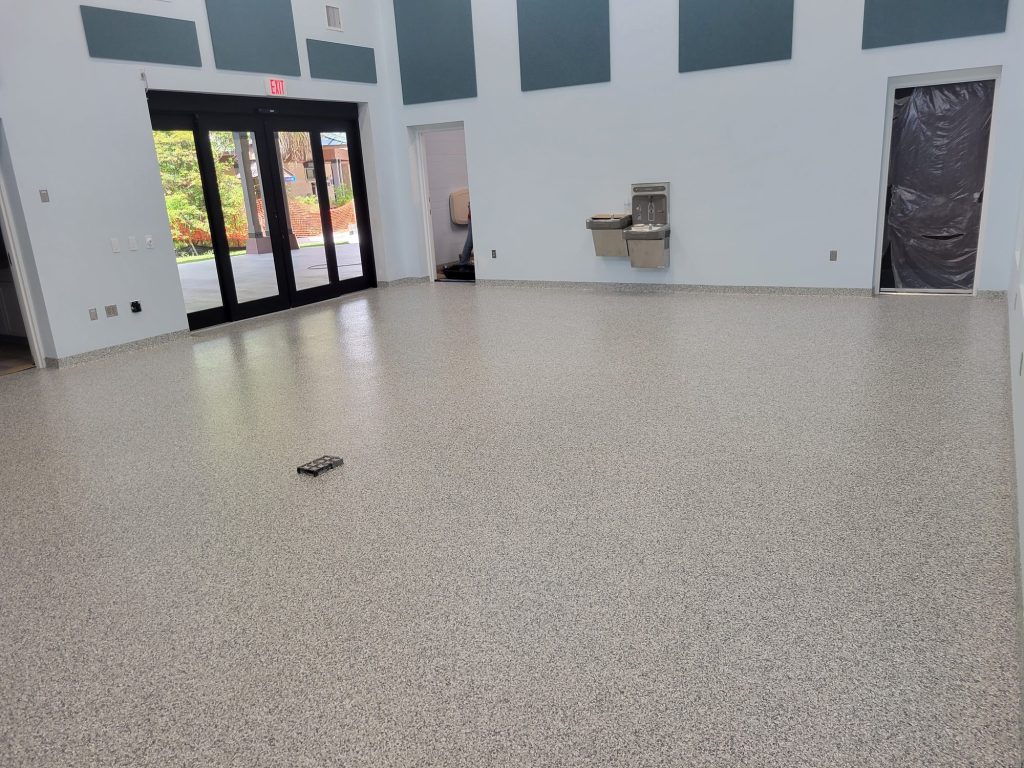 jc-elite-epoxy-flooring-co-owner-jose-rossman Commercial epoxy flooring: tan flake epoxy floor in a commercial lobby with glass doors