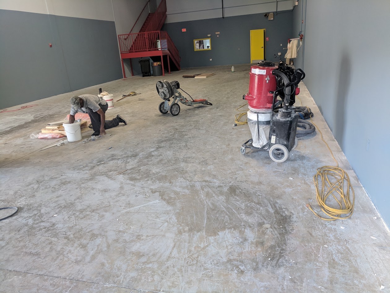 Warehouse floor being ground before an epoxy flake coating
