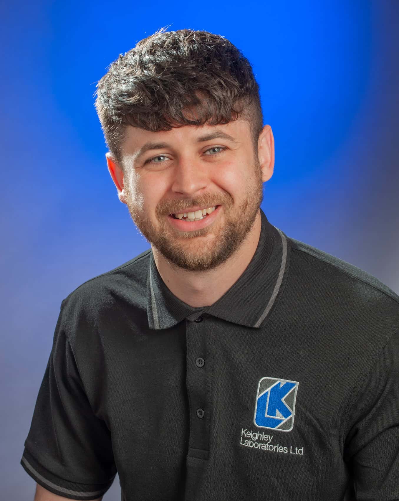 Young male apprentice smiling in Keighley Laboratories uniform.
